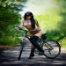 Hot boobs brunette with tattoos riding a bike in the park